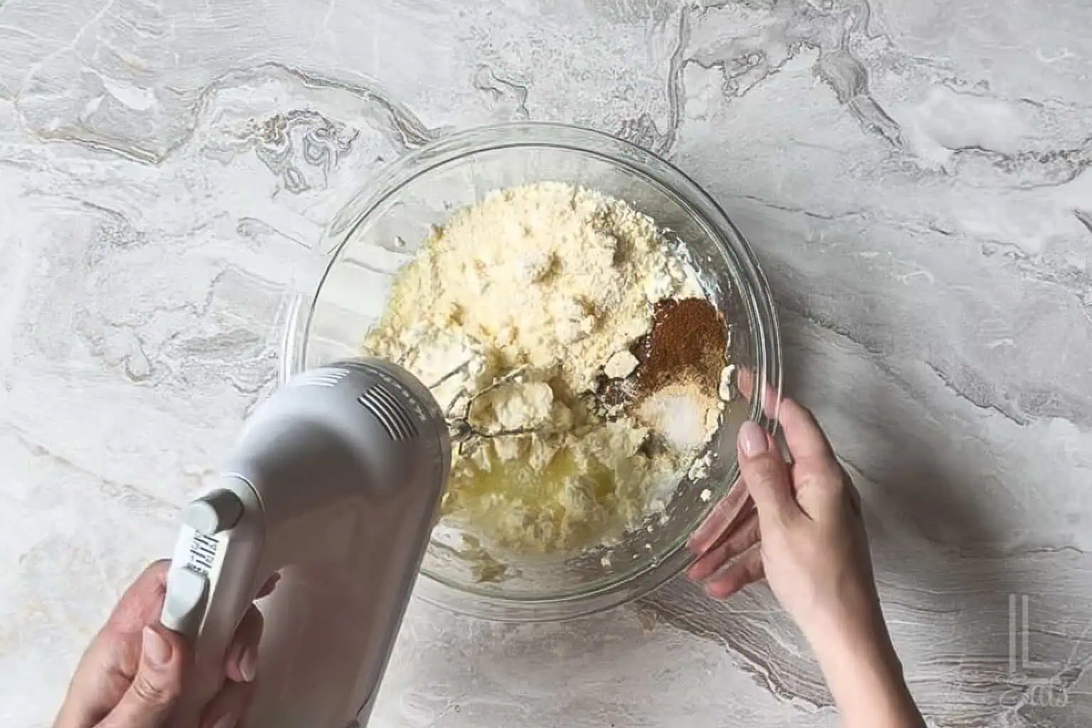 adding spices, parmesan cheese, and lime juice to the creamy elote dip base.