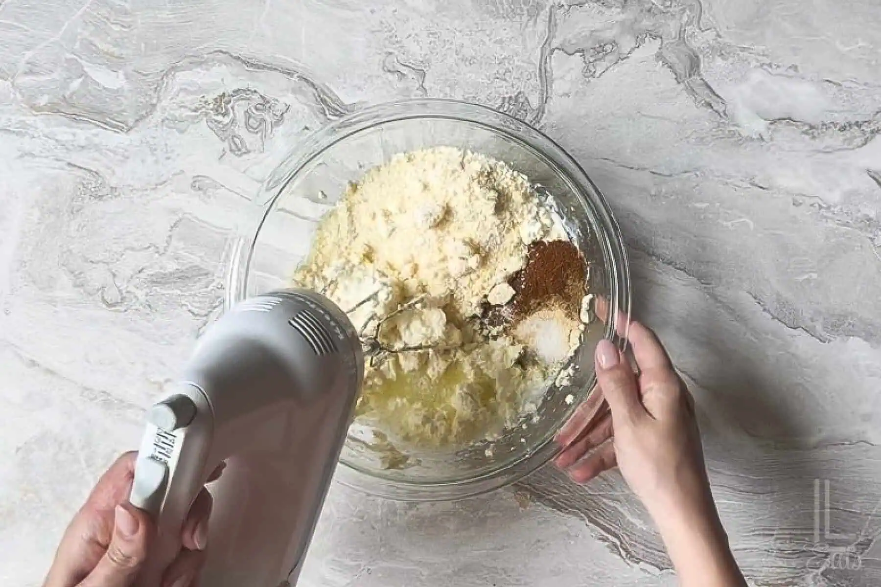 adding spices, parmesan cheese, and lime juice to the creamy elote dip base.