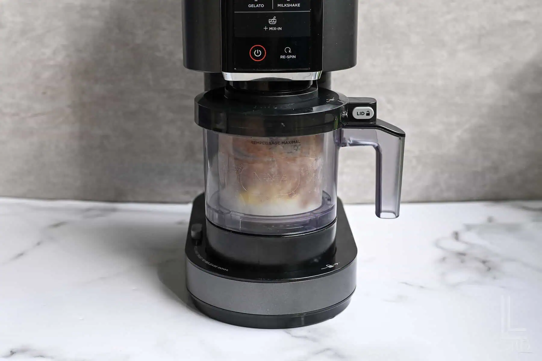 ninja creami protein ice cream in a ninja creami machine, before mixing.