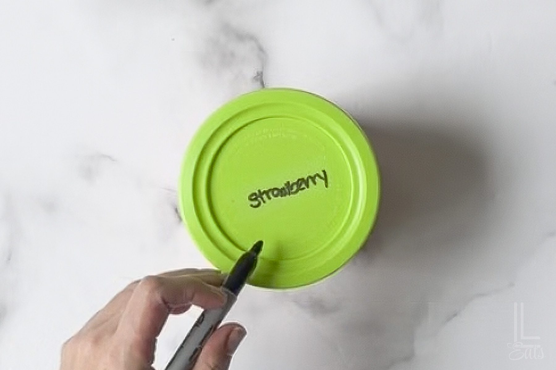 ninja creami container labeled with "strawberry" on the top.