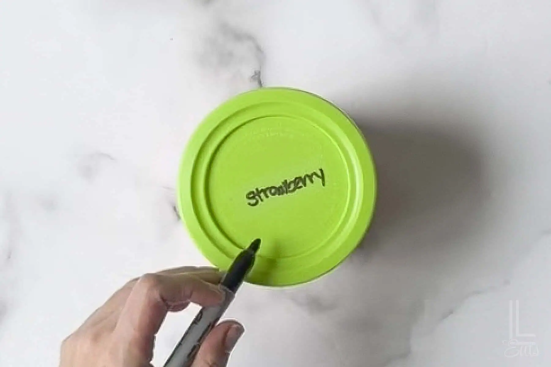 ninja creami container labeled with "strawberry" on the top.