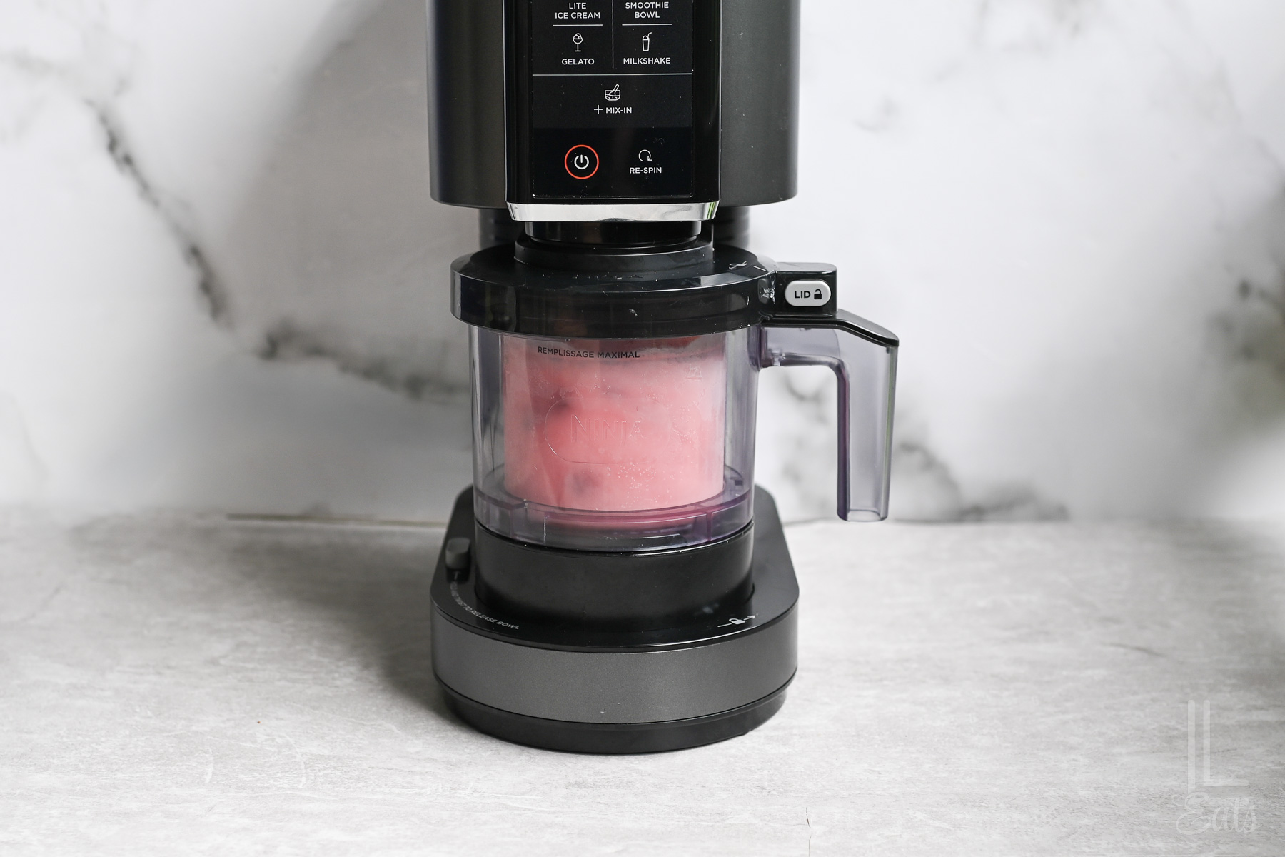 strawberry ice cream being blended in a ninja creami machine.