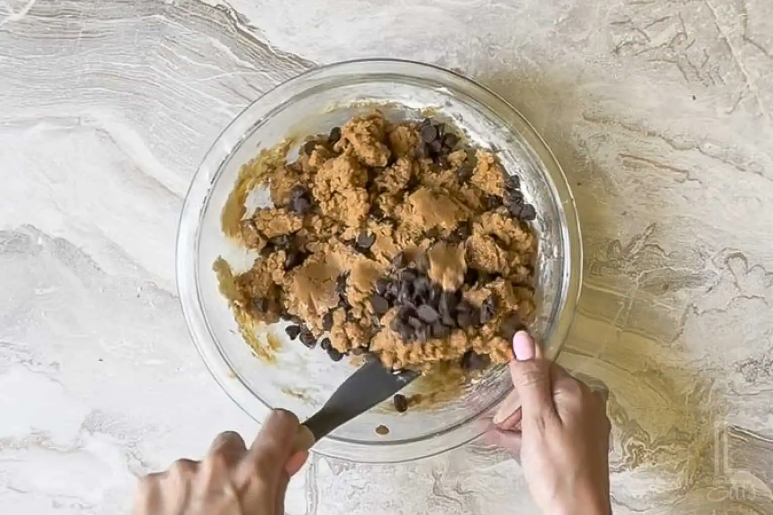 folding chocolate chips into the peanut butter cookie dough.