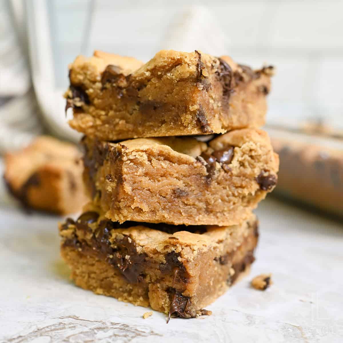 stack of peanut butter cookie bars, showing melted chocolate chips.