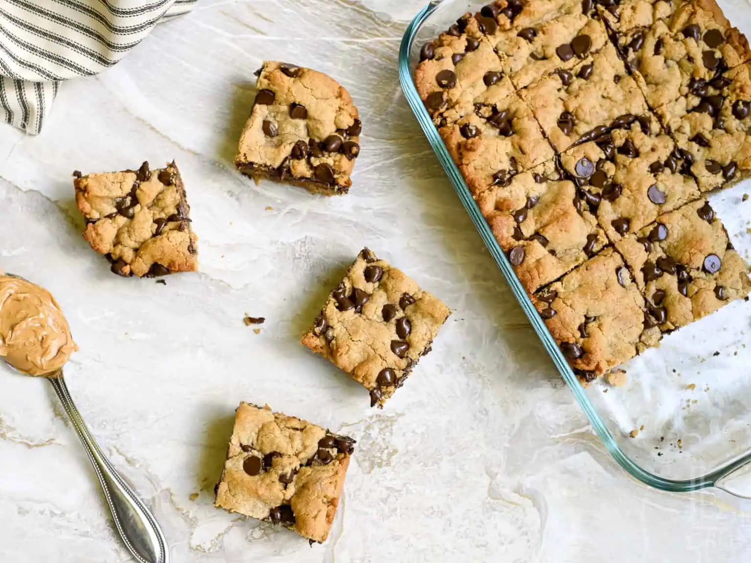 Homemade peanut butter cookie bars with chocolate chips in a glass baking dish.