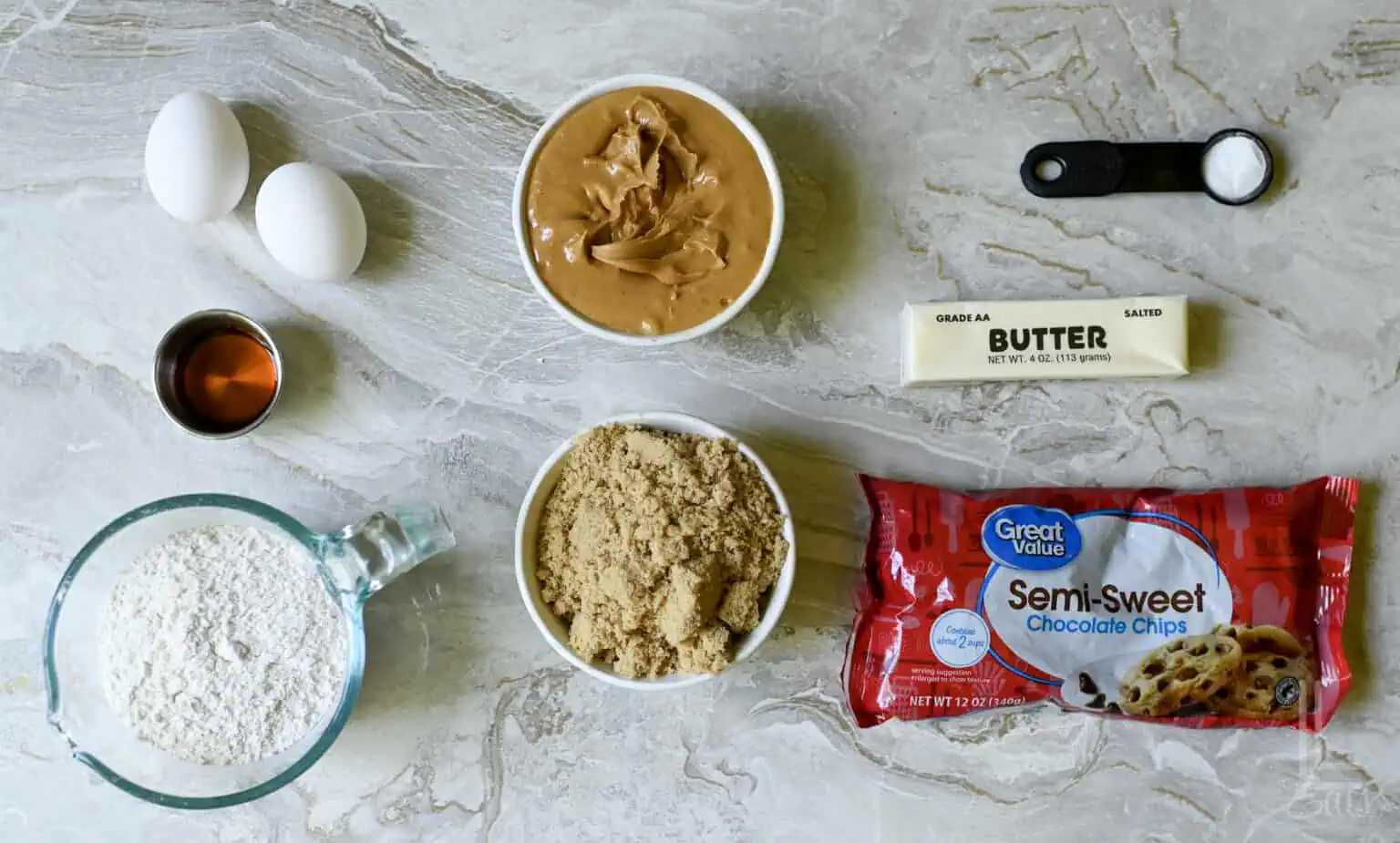 ingredients for peanut butter cookie bars, including peanut butter, brown sugar, butter, and chocolate chips.