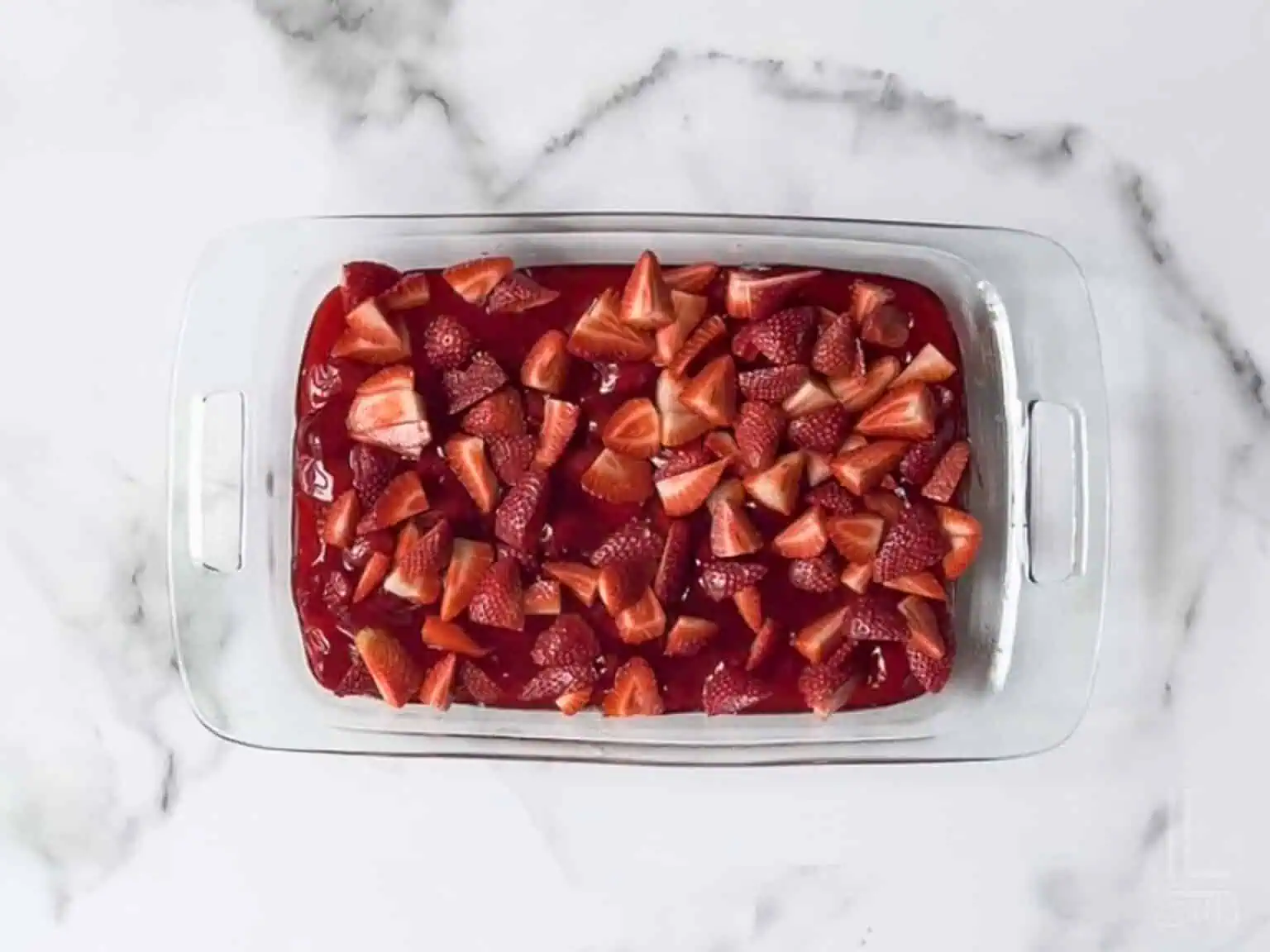 fresh strawberries scattered over the pie filling.