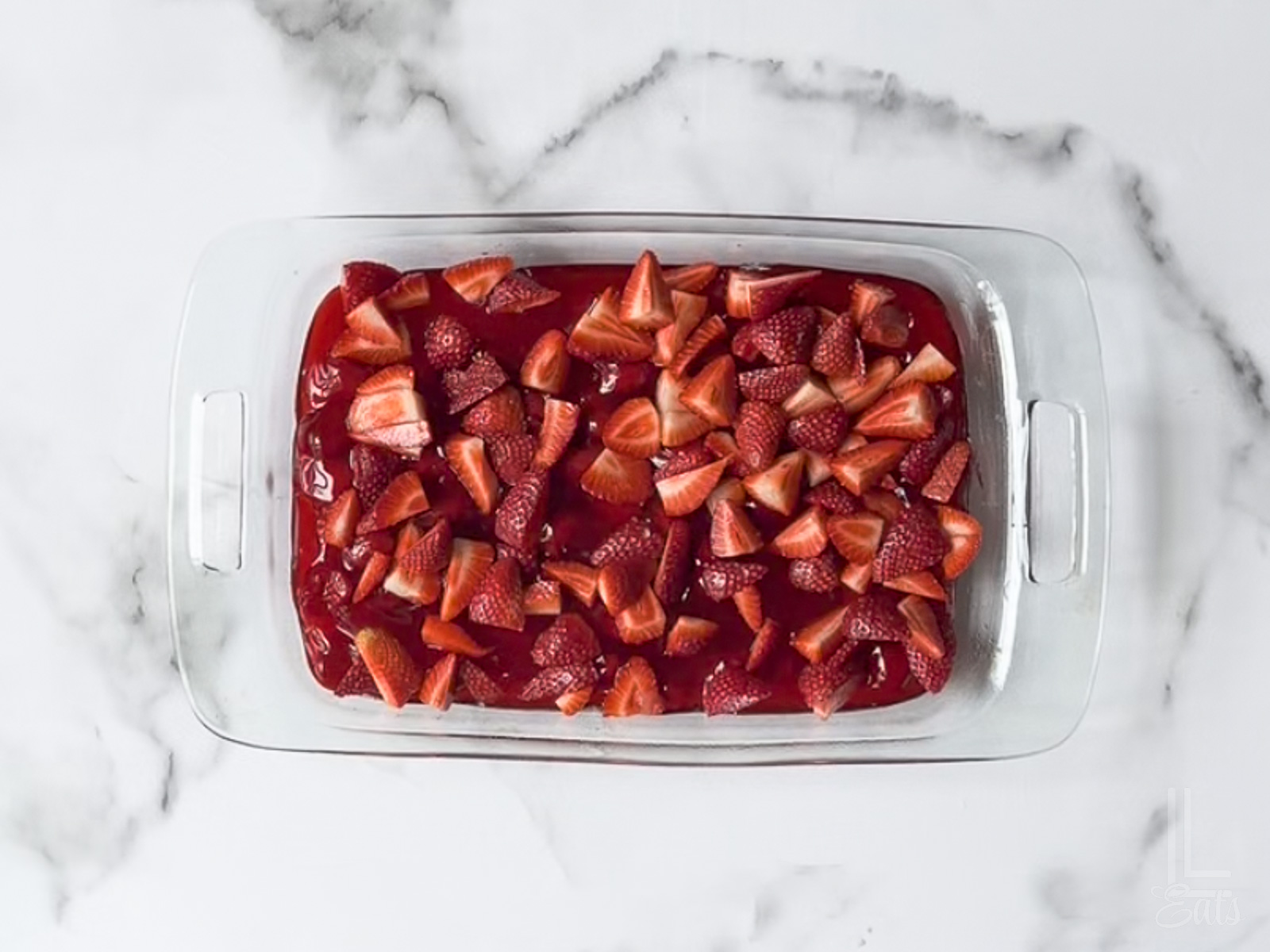 fresh strawberries scattered over the pie filling.