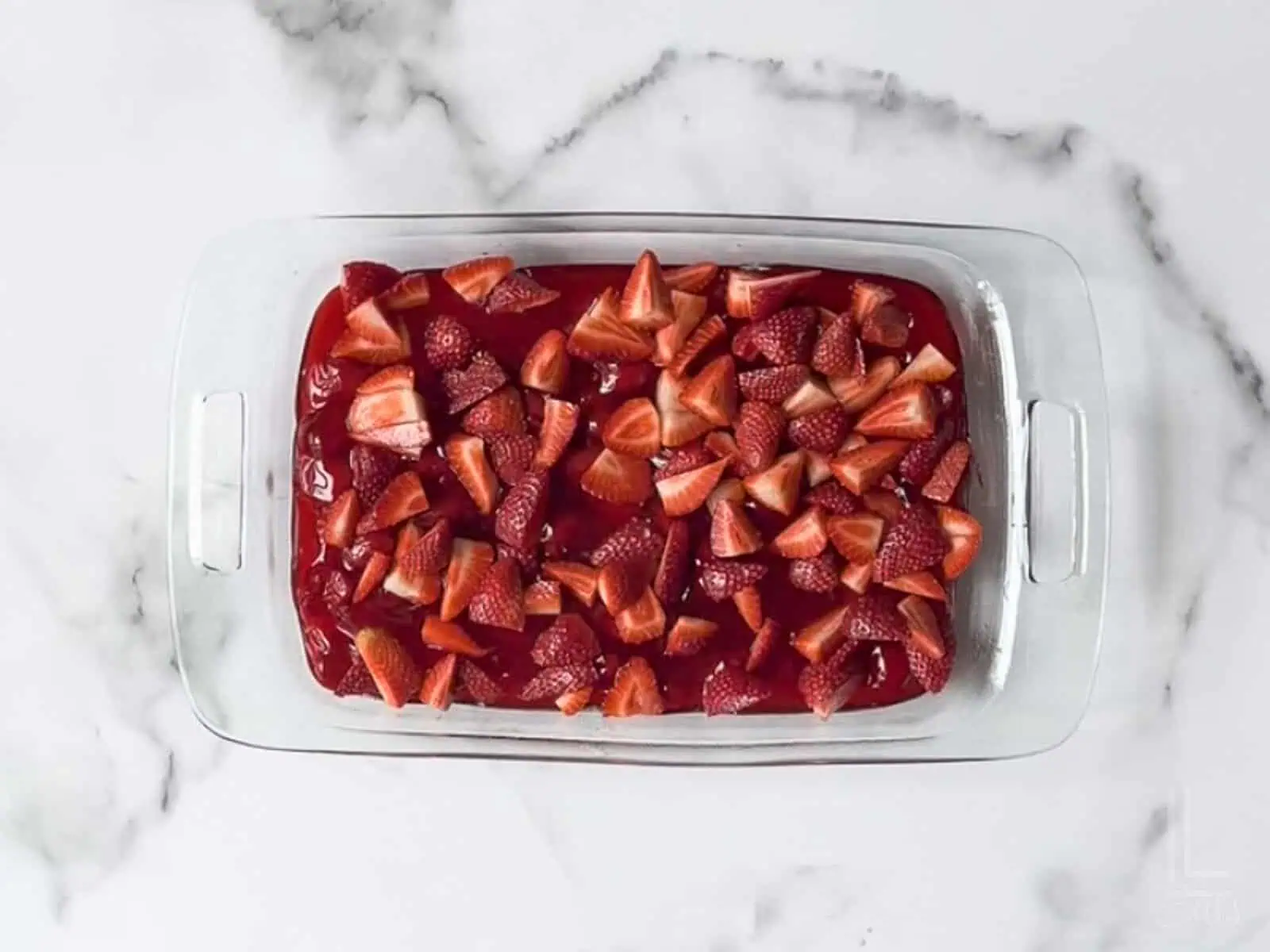 fresh strawberries scattered over the pie filling.