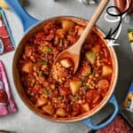 Hearty cowboy stew in a blue pot with potatoes, ground meat, and vegetables, ready in under an hour.
