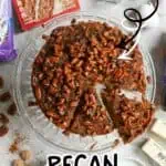 Pecan upside down cake with caramelized pecans on a glass plate, with baking ingredients nearby.
