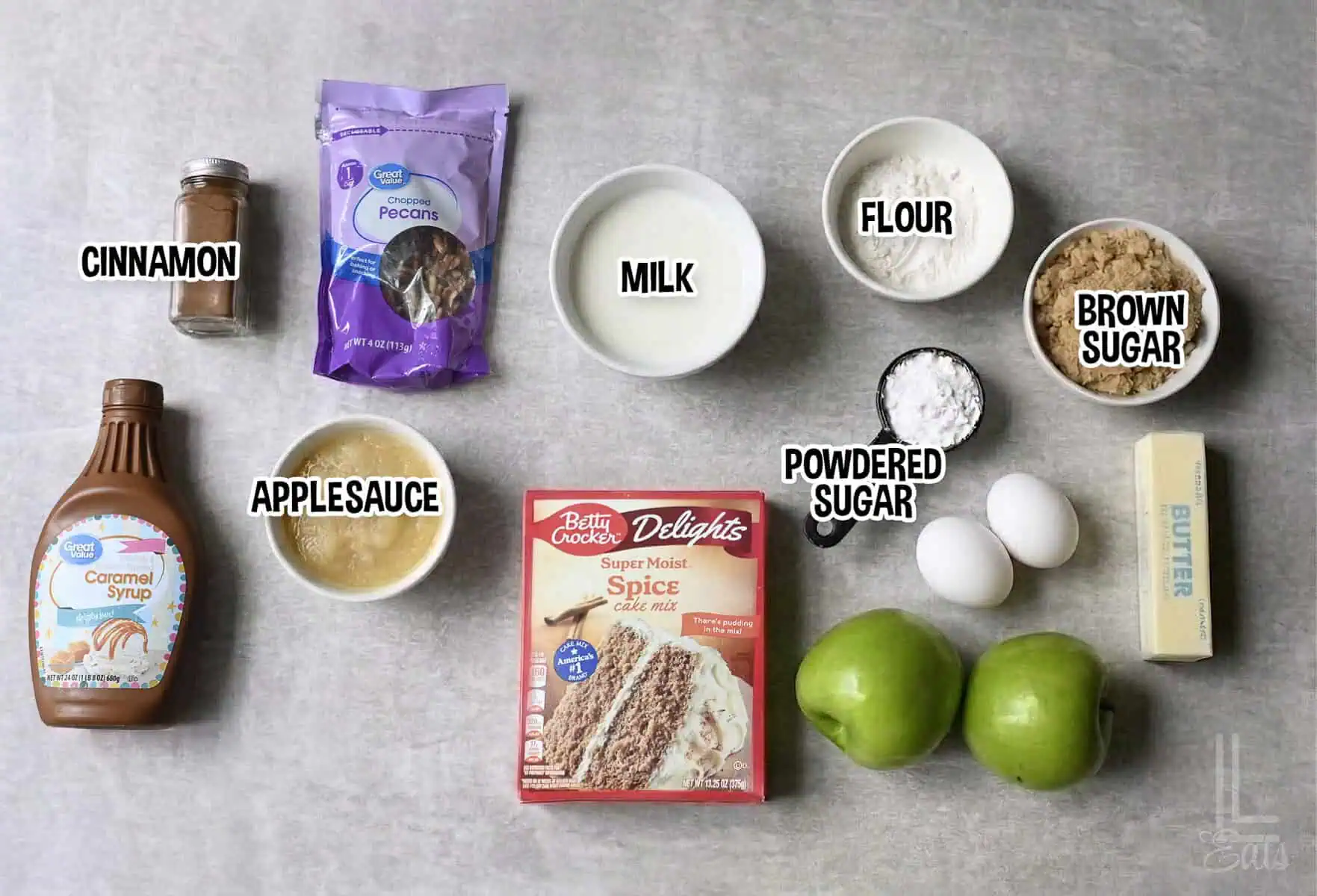 ingredients for apple spice cake, including spice cake mix, applesauce, pecans, and granny smith apples.