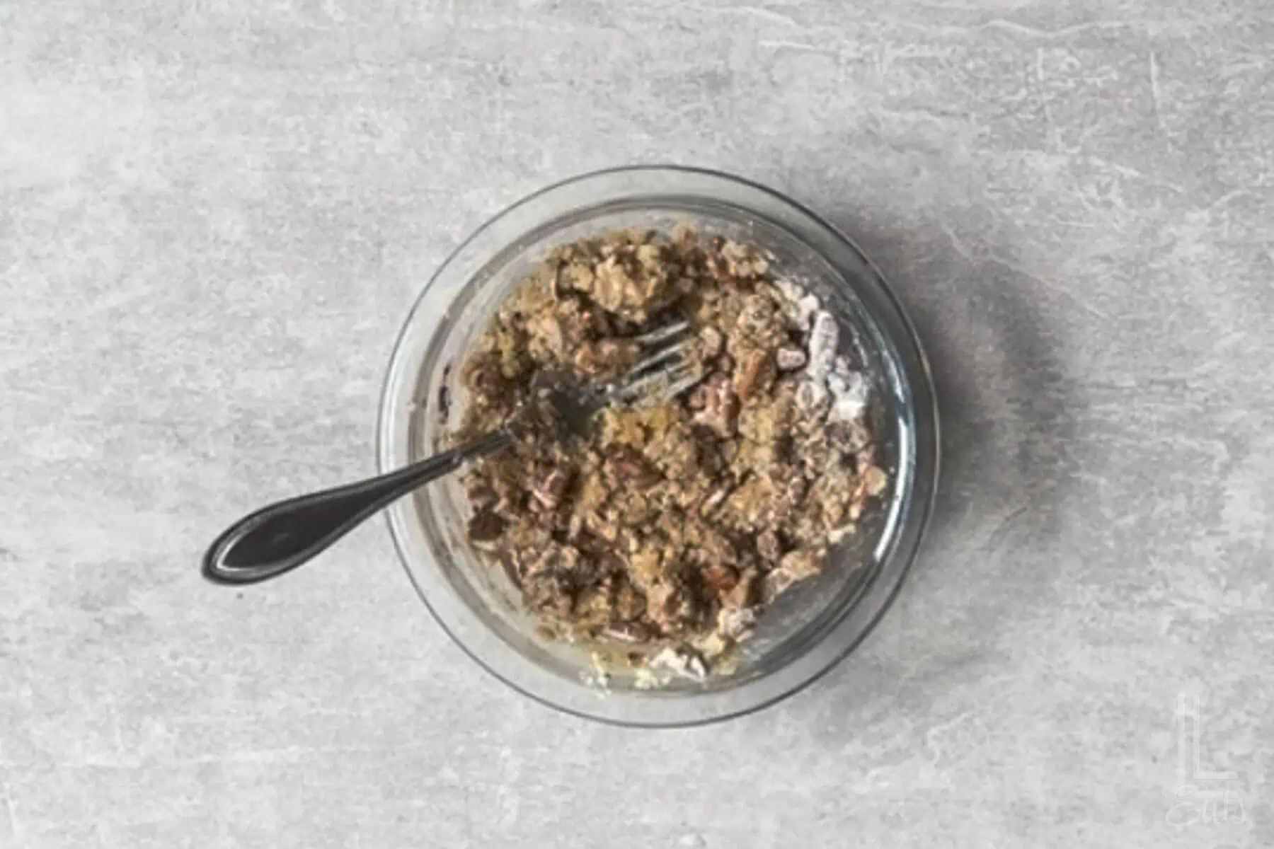 blending the pecan crumble mixture in a small bowl with a fork.