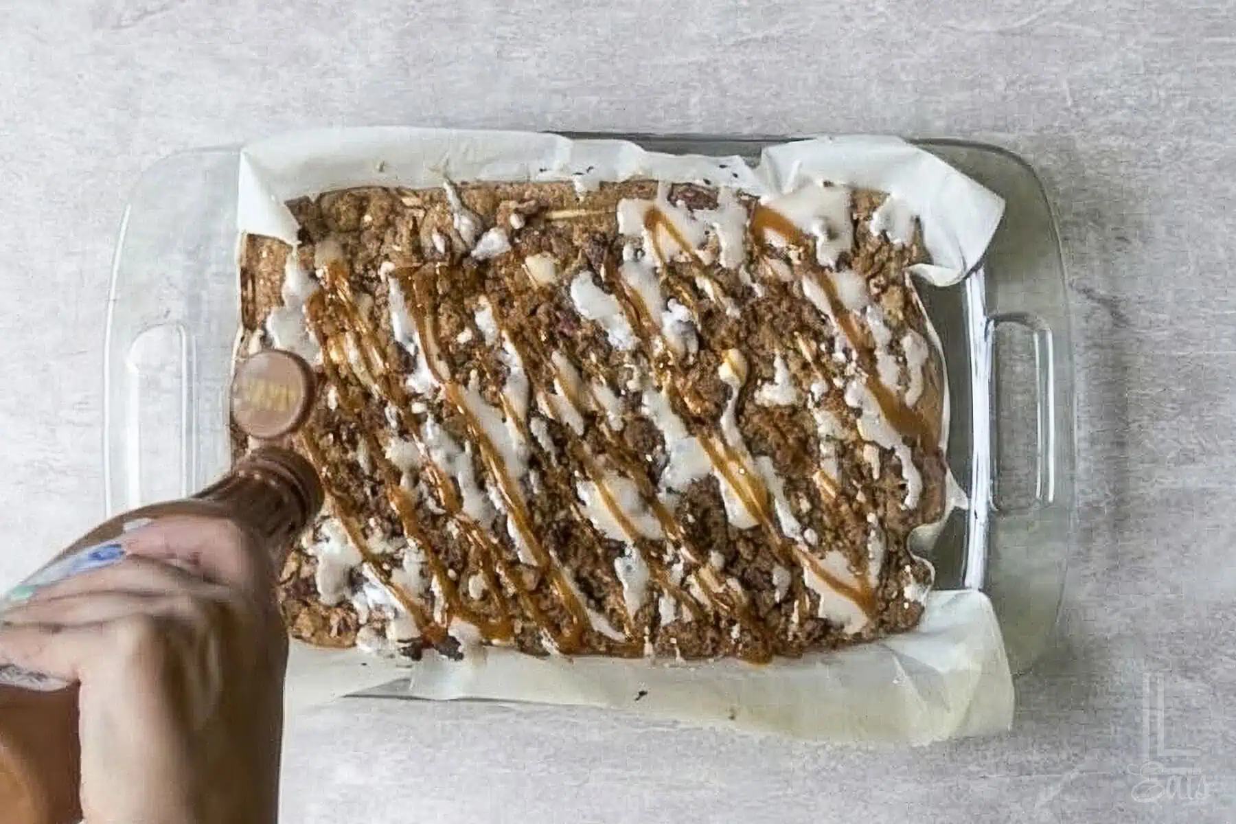 drizzling bottled caramel sauce over the baked apple spice cake.