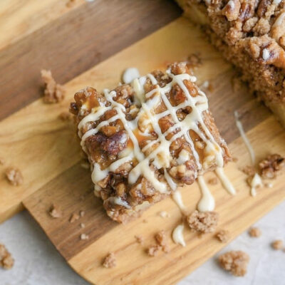 looking down on a piece of spice cake with glaze and caramel sauce on a cutting board.