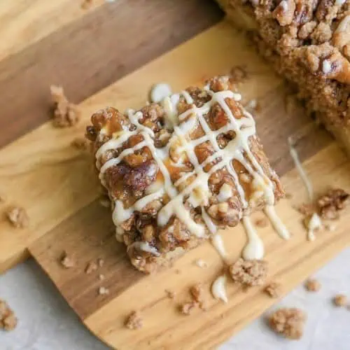 looking down on a piece of spice cake with glaze and caramel sauce on a cutting board.