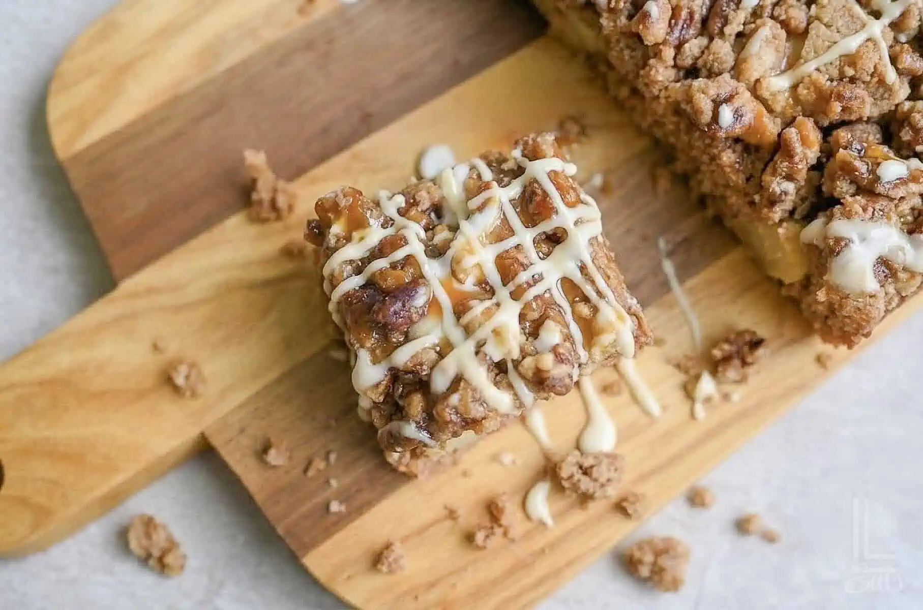 looking down on a piece of spice cake with glaze and caramel sauce on a cutting board.