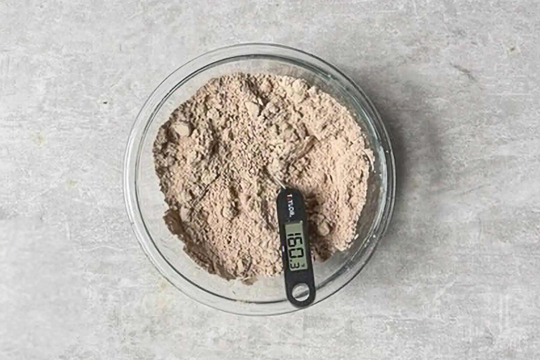 a bowl of brownie mix with a thermometer reading 160 degrees.
