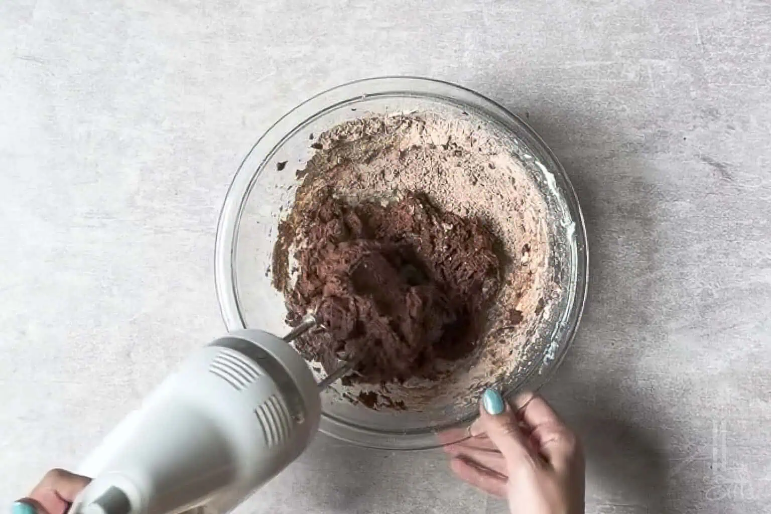 adding the heat treated brownie mix to the whipped cream cheese.