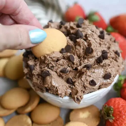 Chocolate brownie batter dip with strawberries and cookies for dessert.