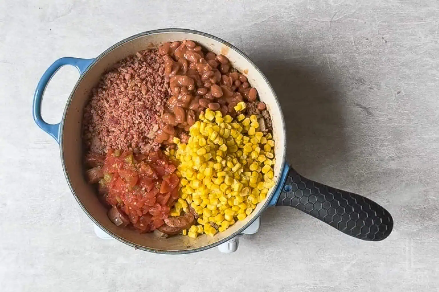 added corn, bacon pieces, rotel, and chili beans to the pot.
