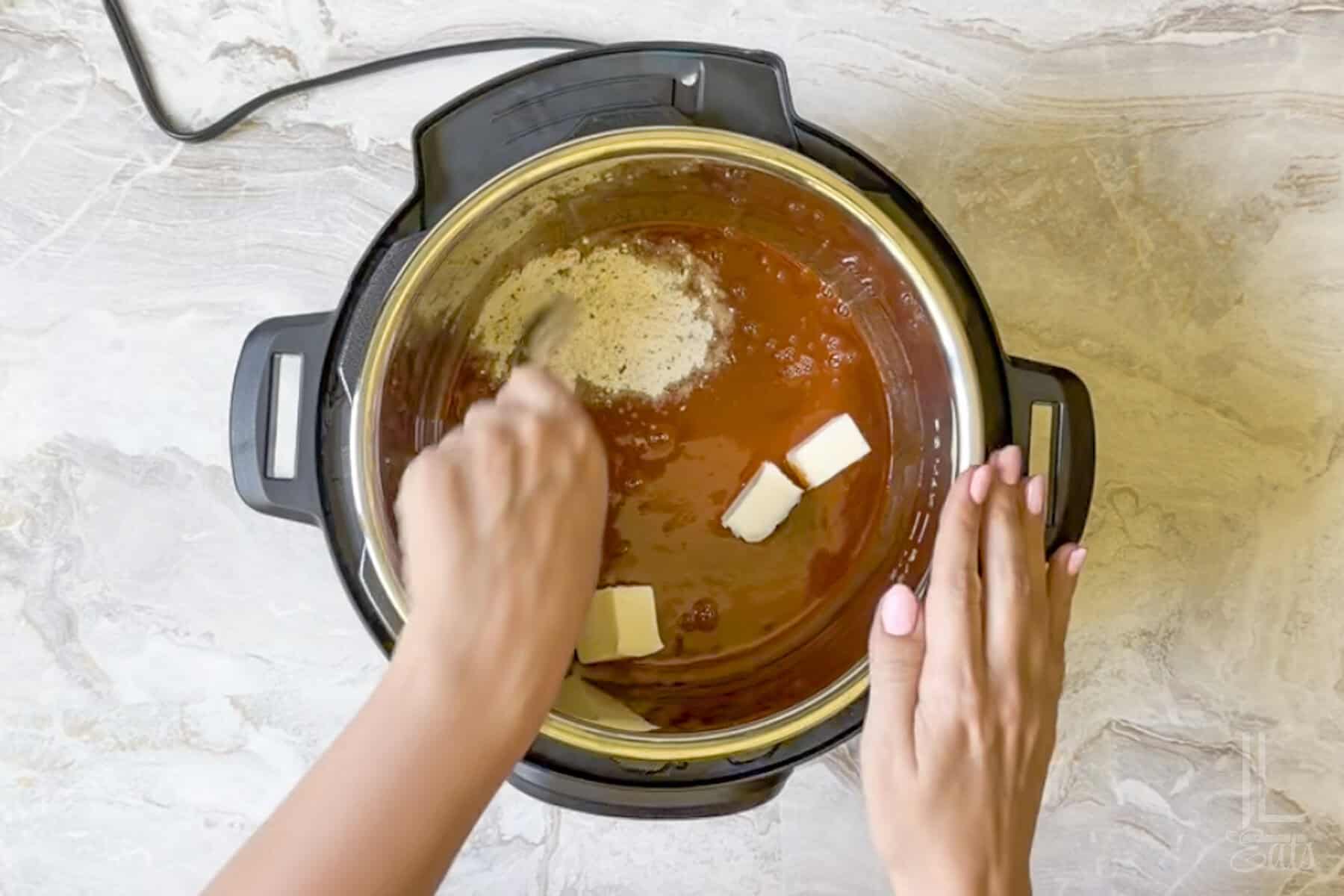 stirring ranch dressing mix, hot sauce, and butter in an instant pot pressure cooker.
