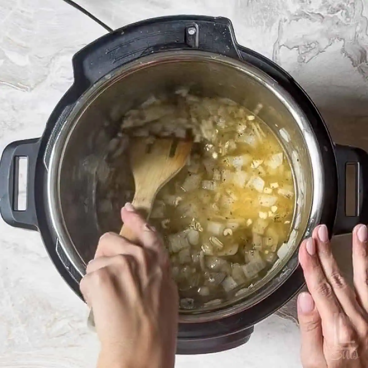 adding chicken broth and scraping the browned bits from the bottom of the pot with a wooden spoon.