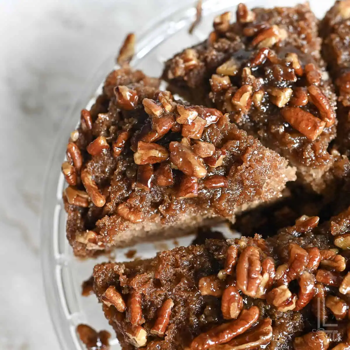 a slice of pecan upside down cake cut on a cake plate.