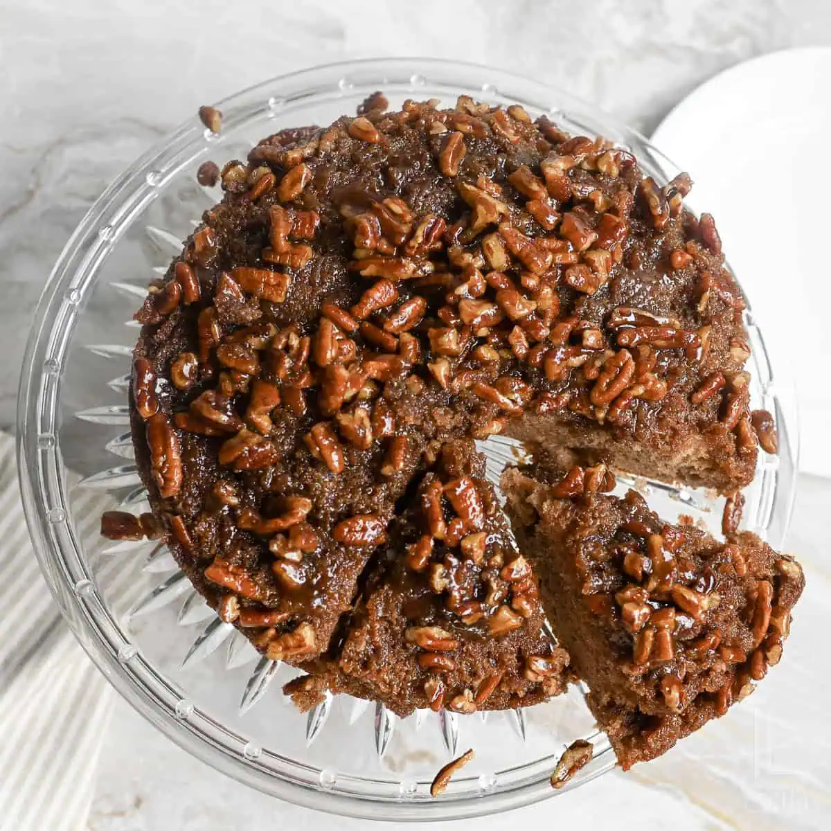 a pecan upside down cake on a cake plate.