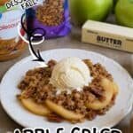 Apple crisp with oatmeal topping served with apples and butter on a white plate.
