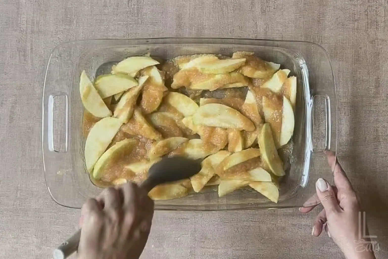 baking dish filled with sliced apples and applesauce stirred together.