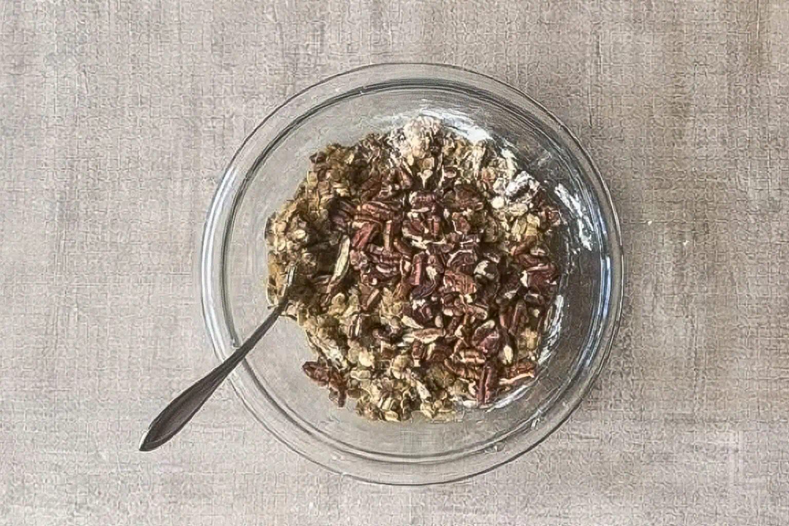bowl of crisp topping with oats and pecans stirred together in a glass bowl.