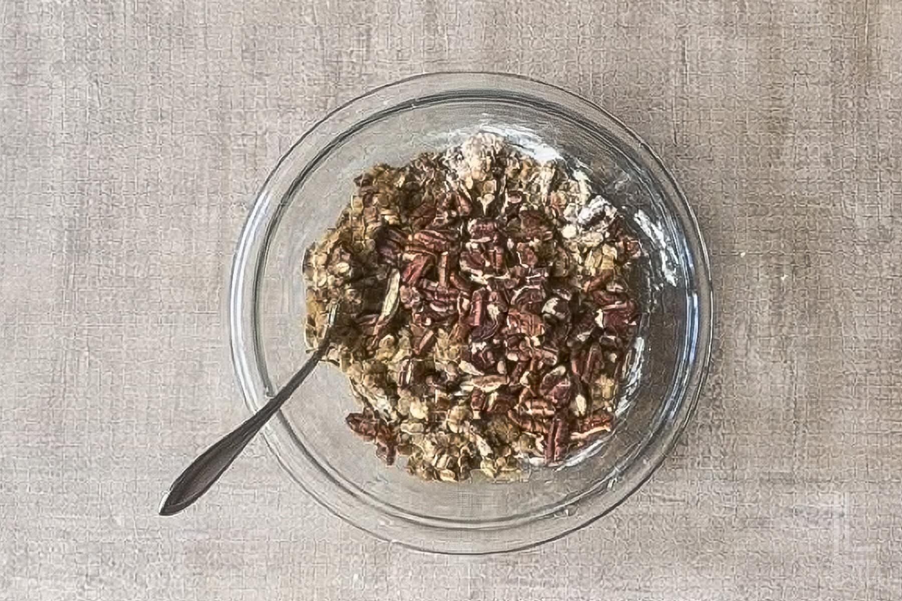bowl of crisp topping with oats and pecans stirred together in a glass bowl.