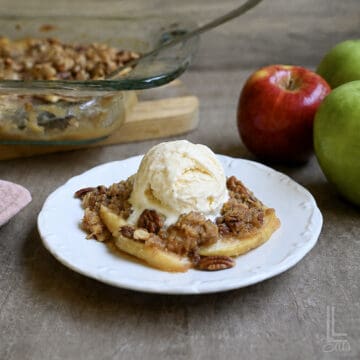 applesauce crisp with oats in a plate, with ice cream on top.