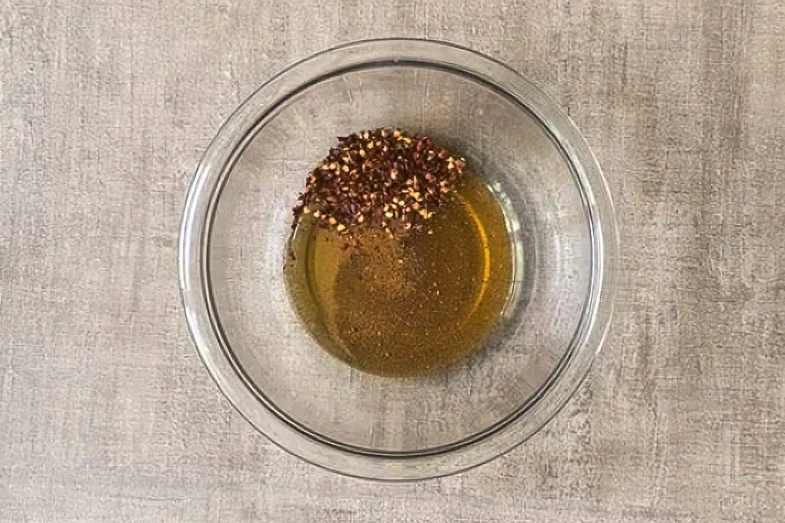Honey with red pepper flakes , apple cider vinegar, and cayenne pepper in a glass bowl.