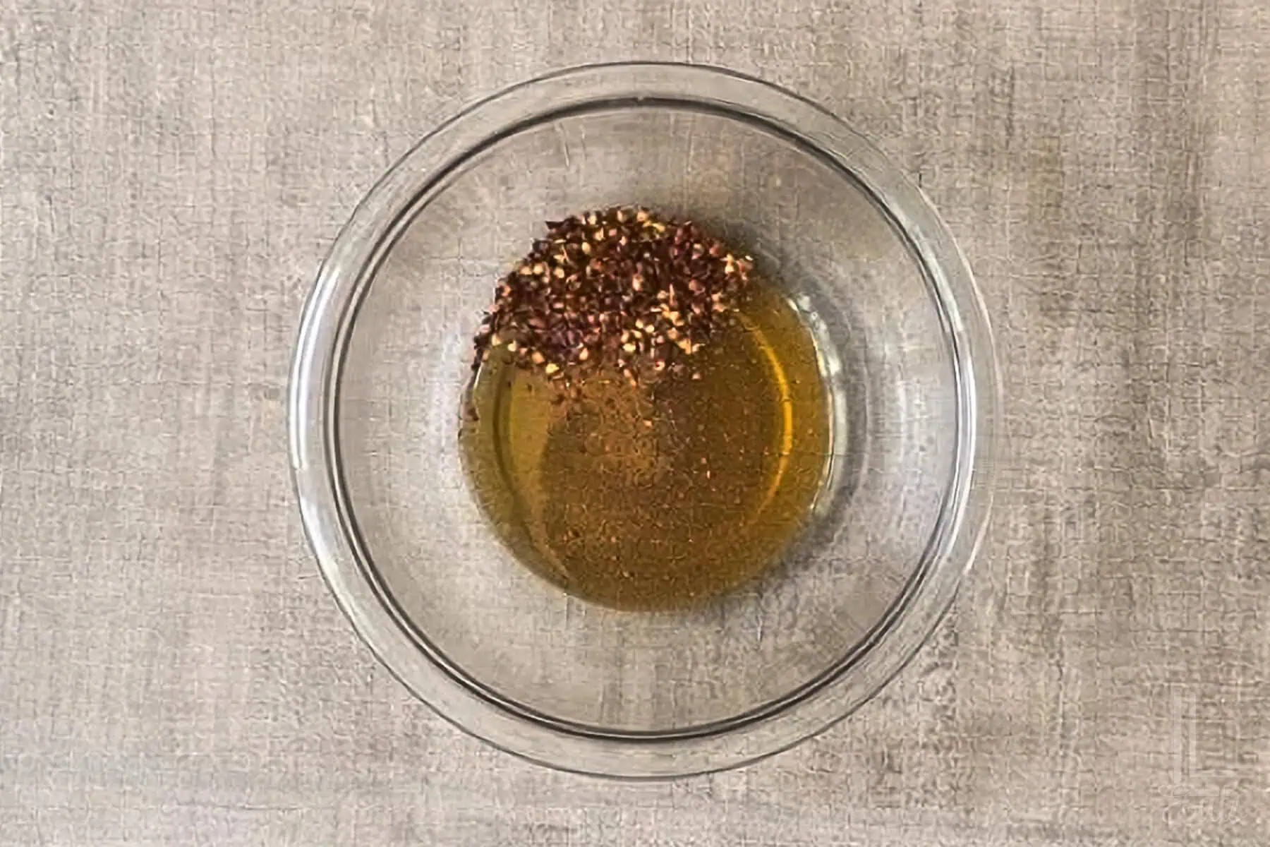 Honey with red pepper flakes , apple cider vinegar, and cayenne pepper in a glass bowl.