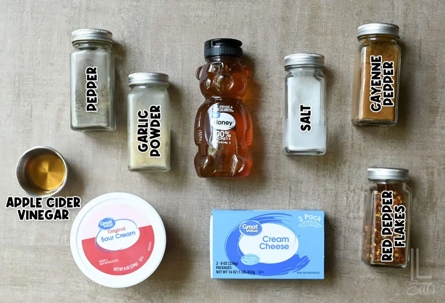 Assorted spices and ingredients for creamy hot honey dip including vinegar, garlic powder, honey, and cream cheese.