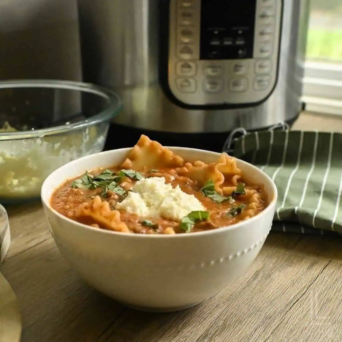 Instant Pot lasagna soup with Italian sausage, lasagna noodles, cheese, and fresh basil.
