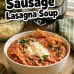 Italian sausage lasagna soup in a white bowl garnished with cheese and herbs.