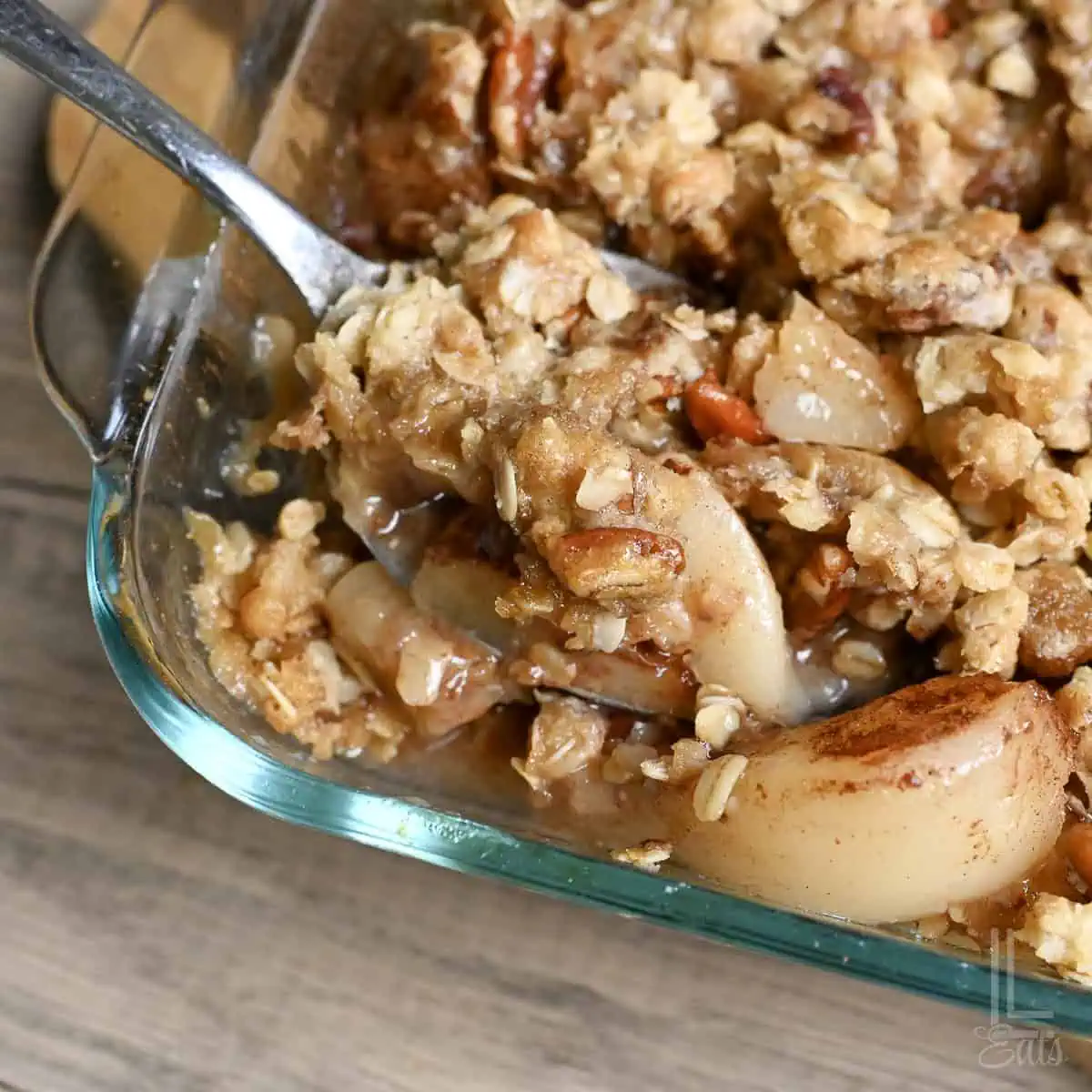 Close-up of pear crumble with canned pears in a glass baking dish.