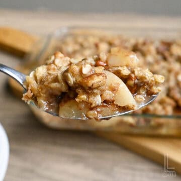 a spoonful of pear crumble, featuring crispy topping and pecans.