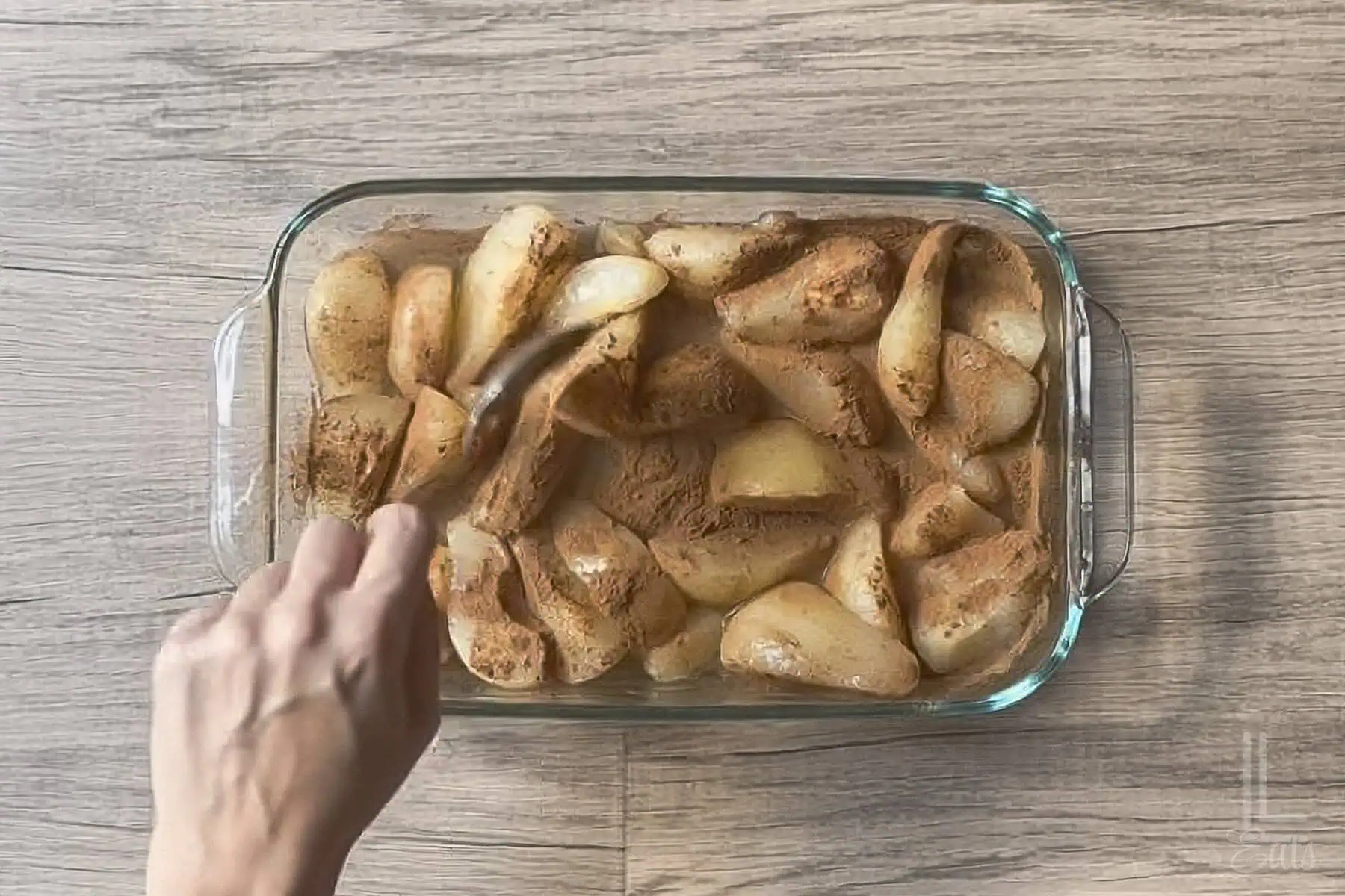 combining canned pears, cinnamon, and lemon juice in a glass baking dish.