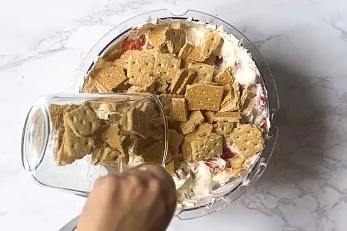 adding crushed graham crackers to the salad mixture.