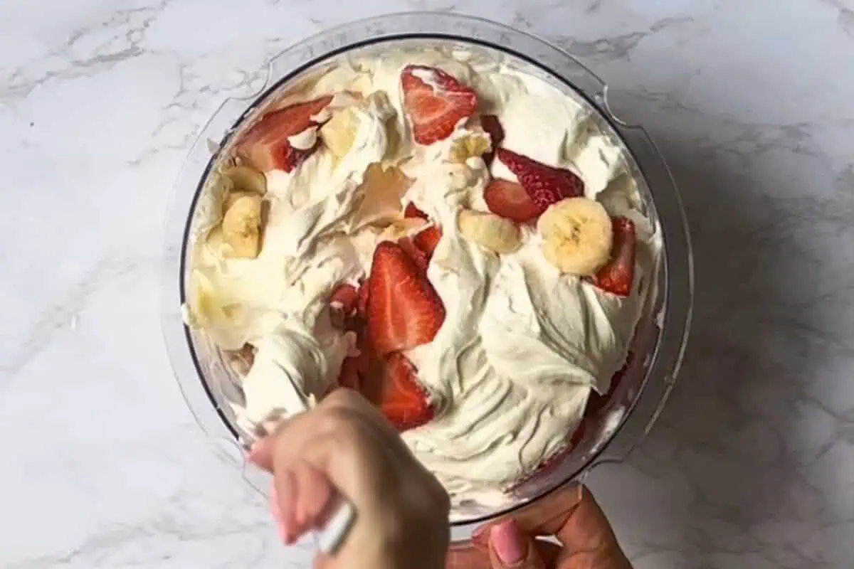folding strawberries and bananas into the creamy cheesecake mixture.