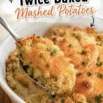 Loaded twice baked mashed potatoes with melted cheese and chives in a baking dish.