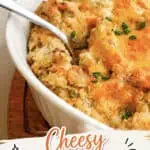 Close-up of cheesy twice baked mashed potatoes garnished with chopped chives in a white baking dish.