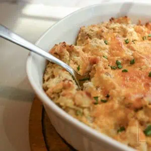 a spoon in a casserole dish of twice baked mashed potatoes.