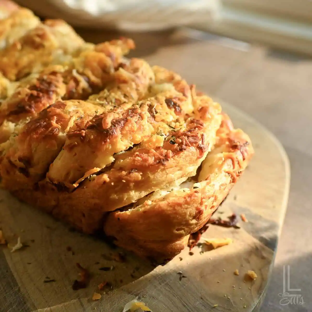 loaf of cheesy garlic pull apart bread on a cutting board.