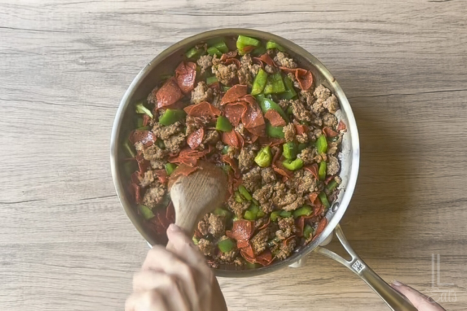 Cooking Italian sausage with pepperoni and green bell peppers in a skillet for Crock Pot Pizza Dip.
