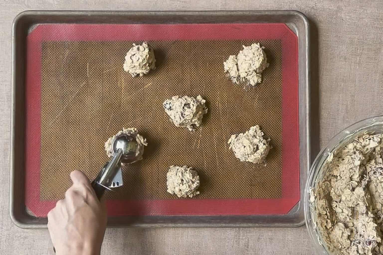 Oatmeal cranberry cookie dough with white chocolate on baking sheet ready for baking.